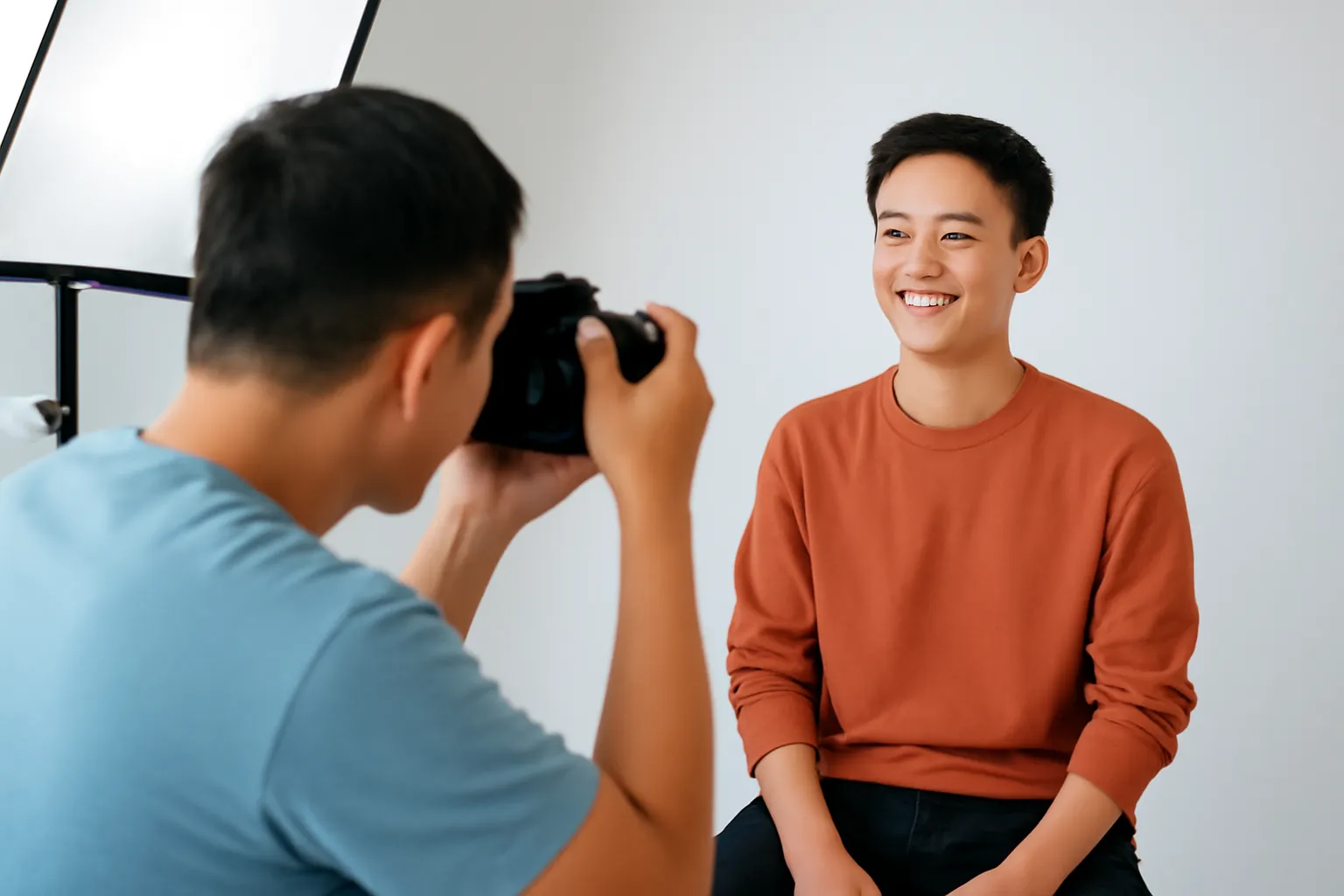 Thợ ảnh chụp chân dung nghệ sĩ trẻ trên nền phông trơn trong studio sáng